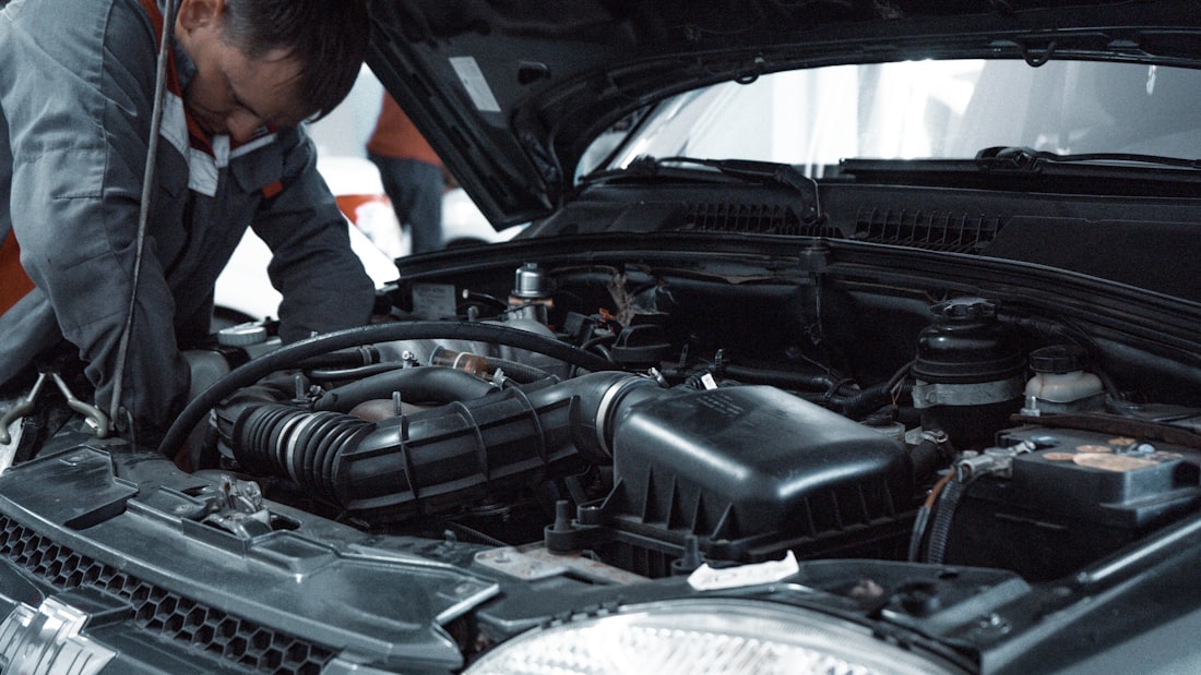Hands deep in an engine bay during a transmission diagnosis